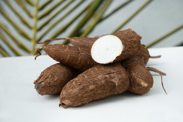 Organic raw Cassava or manioc tuber on white background. Yucca cassava root. Popular Indonesian and...