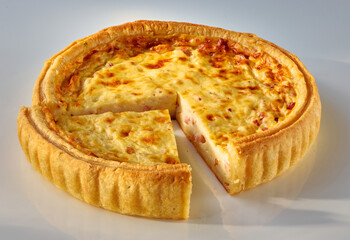 Quiche mit herausgeschnittenem Viertel auf weissem Fond, isoliert, Quiche lorraine, Auflauf, gebacken,