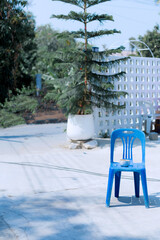 Blue plastic chairs and red plastic water buckets are placed outdoors.