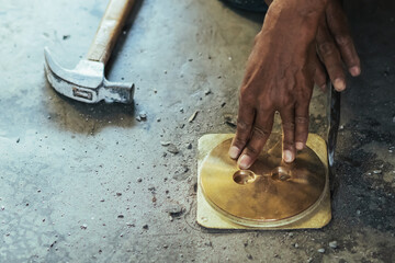 Elderly worker of water utility maintenance service change sewer manholes in house. Hands of old man changing and repairing brass sewer cover of sewerage system. Maintenance of toilet drainage system.