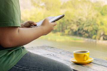 Hands of young woman using two phones simultaneously. Happy woman use two modern smartphones...
