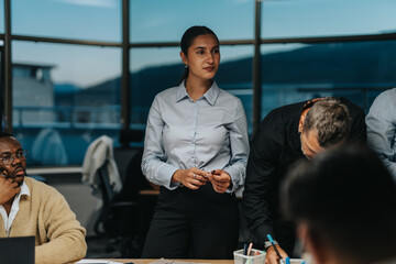 A diverse group of colleagues brainstorm in an office, focusing on project solutions and ideas. The...