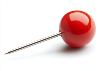 Colorful red push pin resting on a white surface showcasing its glossy finish and sharp metallic tip