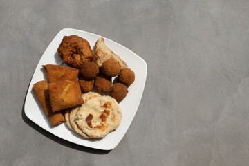 Authentic Sri Lankan different street food, short eats. Vegetable roti, Chinese Rolls , coconut roti, cutlets, mutton rolls on gray background. Snacks made with tuna, potatoes, onion and deep fried