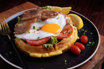 Fried Egg and Pork Waffles Food in a black plate on a wooden 