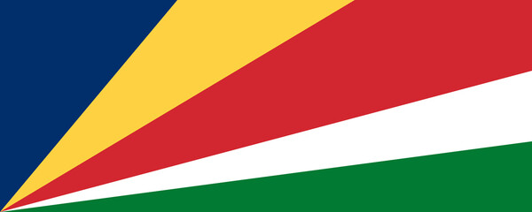 Flag of Seychelles waving against a clear sky during a warm afternoon on the island