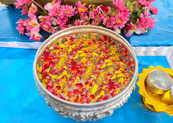 Silver bowl filled with pure water and sprinkled with flower petals such as roses and marigolds. Used for bathing Buddha images, pouring water to ask for blessings from elders, during Songkran festiva