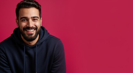 Obraz premium Portrait of smiling man in blue hoodie against pink background for modern design
