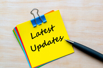 Latest updates text on yellow notepad. Business Updates concept