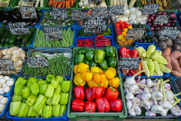 Vibrant display of fresh vegetables and produce fills market crates, showcasing an array of colors and textures at Naschmarkt, Vienna, Austria. Grocery shopping in city centre. Diversified selection