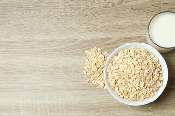 Composition with oatmeal flakes on wooden background. Cooking breakfast