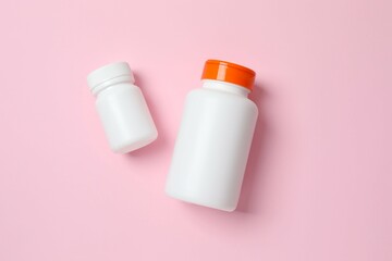 White bottles on color  background, top view