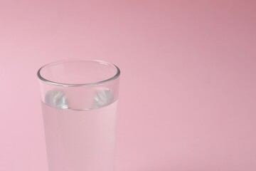 Glass of water on color background
