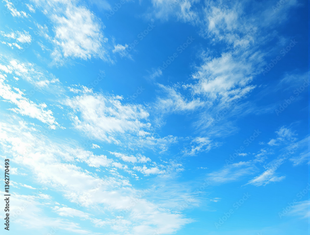 Poster clear blue sky with soft white clouds scattered across, creating a serene and peaceful atmosphere. p