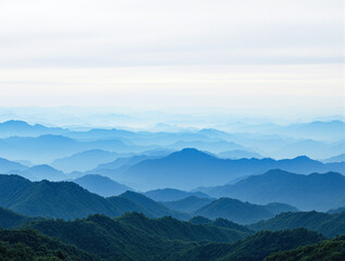 Naklejka premium Scenic mountain landscape with layers of blue ridges fading into the misty horizon under a soft, bright sky, creating a peaceful background. Ai generative