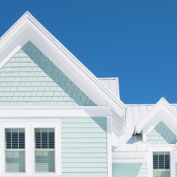 Exterior of white coastal cottage against clear blue sky