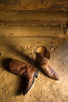 Overhead view of pair of leather cowboy boots in stable