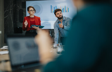 A multicultural team engaged in a business meeting, analyzing data on a screen. The atmosphere is collaborative and focused, emphasizing teamwork and communication in a professional environment.