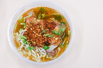 Pork tom yum noodles in a bowl on the table