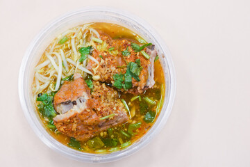 Pork tom yum noodles in a bowl on the table