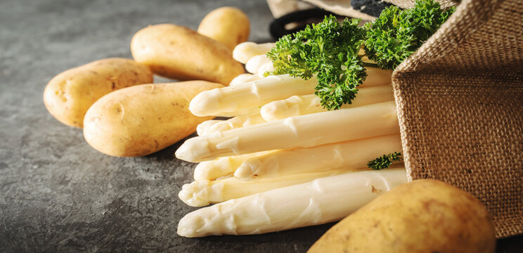 Shopping bag filled with ingredients from the market for an asparagus meal. Fresh regional products for healthy eating. Saisonal gastronomy concept with space for text. Healthy food background.