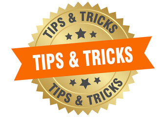 tips & tricks. tips & tricks round orange and gold label isolated on transparent background