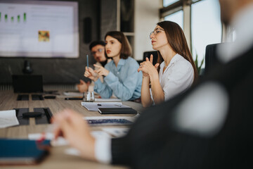 A multicultural group of business people engaged in a collaborative meeting. The team is focused,...