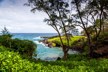 Naklejka premium Beautiful coastline in Hana, Maui, Hawaii with turquoise water and gentle waves hitting volcanic rock formations