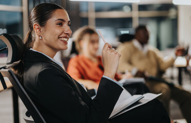 A businesswoman actively participates in a team meeting. She exudes confidence and attentiveness,...