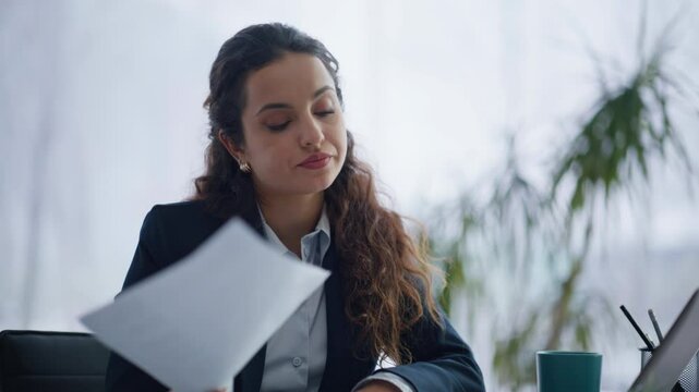 Tired accountant doing paperwork watching documents at agency cabinet closeup