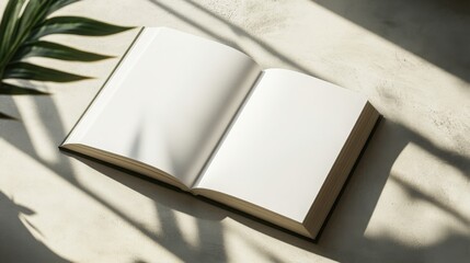 Flat lay hardcover book mockup, open book with blank white pages, lying flat on a light concrete surface
