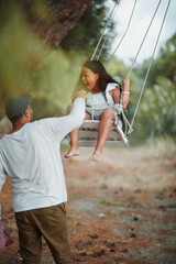 Dad rocks his daughter on a homemade swing