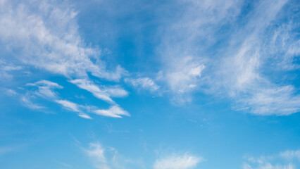 Beautiful bright blue sky filled with delicate and wispy white clouds, creating a serene and tranquil atmosphere ideal for nature, outdoor, and environmental concepts.