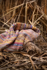 Warm background photo of colored wool scarf on natural background, art photo in muted warm colors.