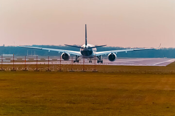 Fototapeta na wymiar Passenger jet airplane on a sunny summer sunset at Munich airport, MUC, Freising, Bavaria, Germany