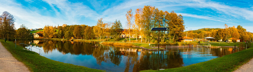 High resolution stitched autumn or indian summer panorama with reflections in a lake at Arrach, Cham, Bavarian Forest, Bavaria, Germany