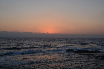 Serene ocean sunset with gentle waves and vibrant horizon