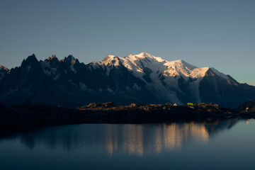 Peaks of the Mont Blanc massif illuminated in morning sunlight and reflected in Lac Blanc