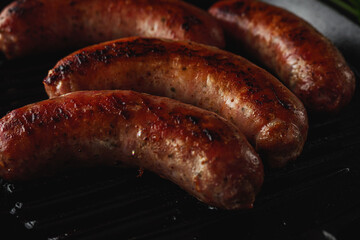 Pork sausages grilled on a pan. Image in dark tones