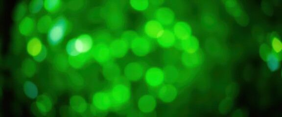 Naklejka premium Abstract green bokeh lights, blurred nature background, leaves, glow