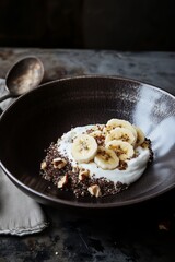 Banana quinoa yogurt bowl with nuts on dark ceramic plate