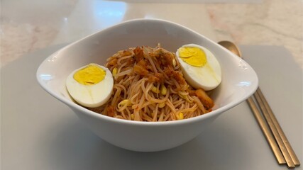 Spicy Korean cold noodles with bean sprouts and boiled egg