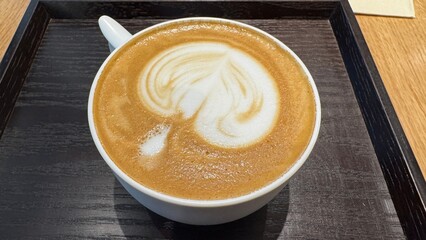 Latte with heart-shaped milk foam art in a white cup