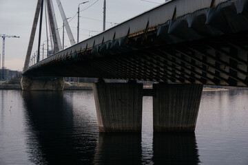 A striking perspective of a cable-stayed bridge over a calm river, showcasing urban infrastructure and architectural design