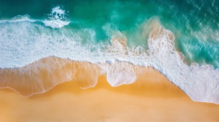 Turquoise ocean waves crashing on golden sandy beach aerial view
