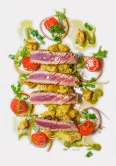tuna steak on orange salad with pistachios and toasted bread 