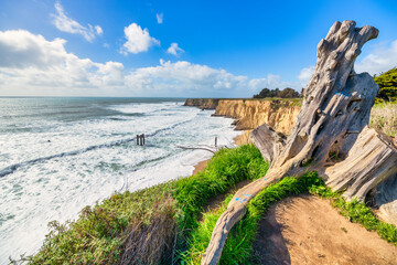 Scenic coastal view near Davenport Landing Beach, California. Dramatic cliffs, turquoise waves, and...