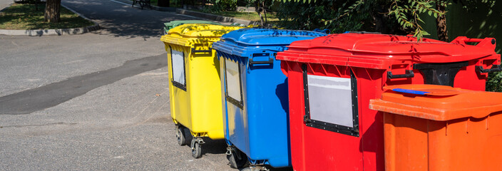 Different colored trash cans in the neighborhood, garbage recycling and sorting concept