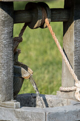 A tiny well with water coming from a bucket