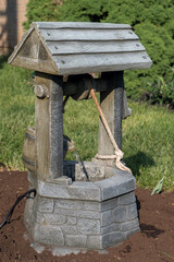 A tiny well with water coming from a bucket